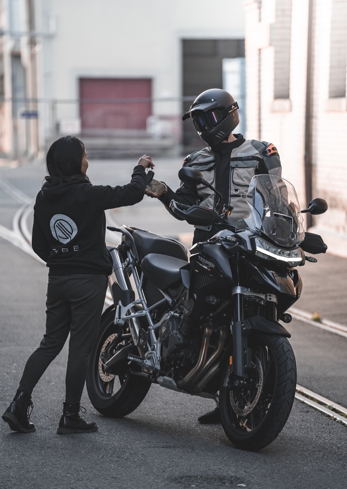 A woman handing keys to a bike rider